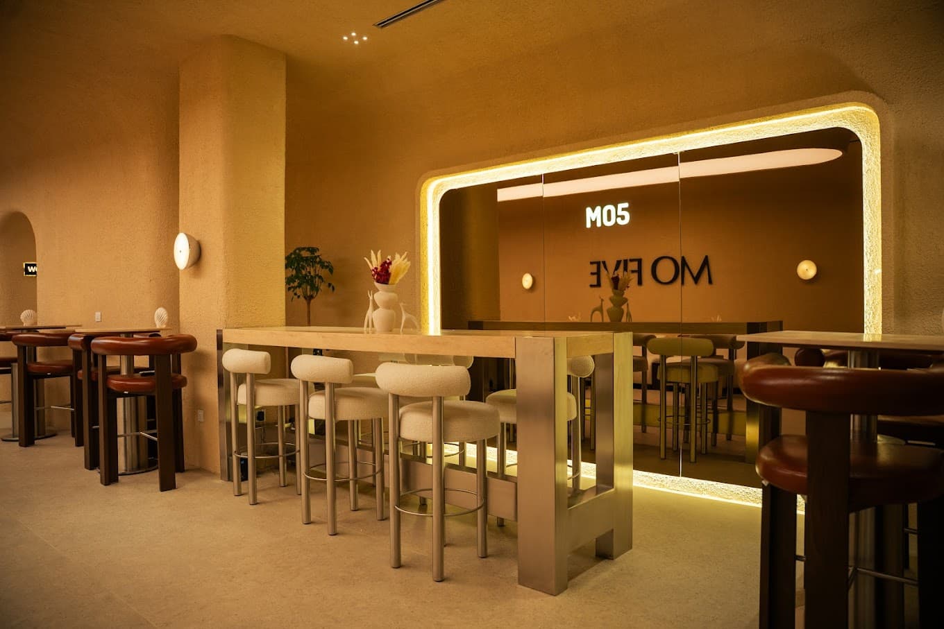 Backlit MO FIVE lounge with warm mirrors and seating