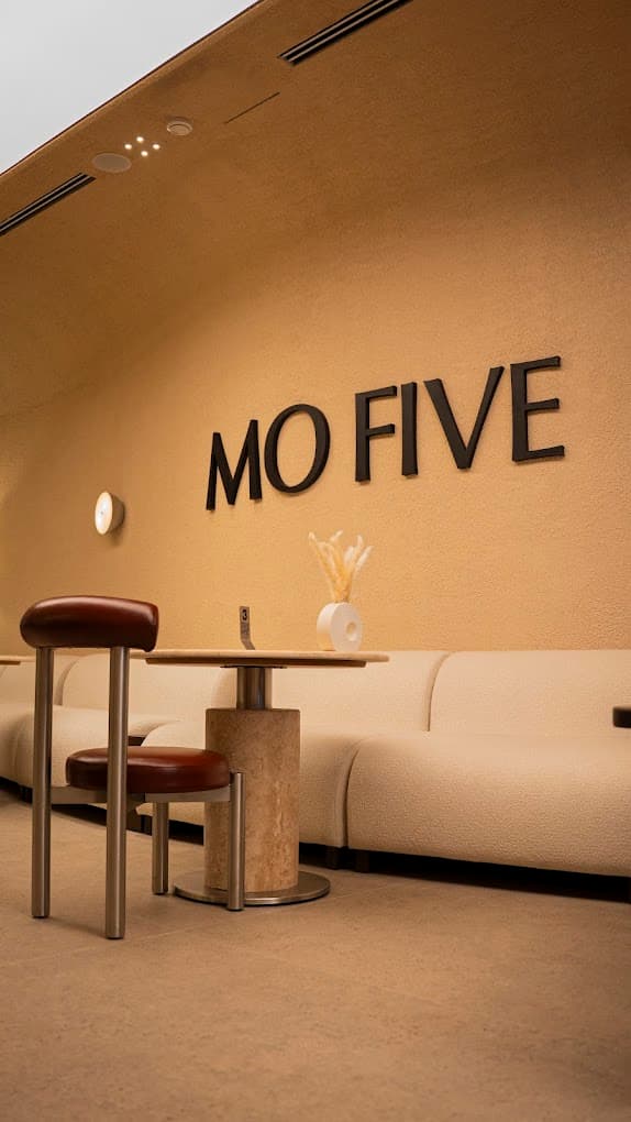 MO FIVE wall sign above a travertine table